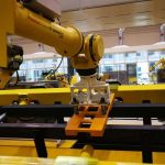 robot end effector picking up steel workframe in conveyor line - HVR MAG