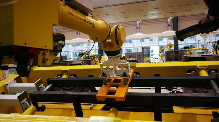 robot end effector picking up steel workframe in conveyor line - HVR MAG